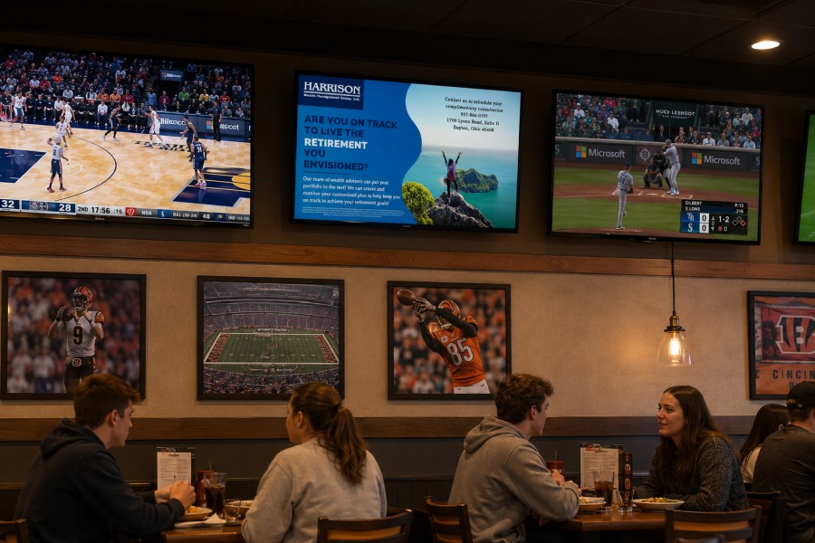 Digital signage promoting beverage specials inside a restaurant dining room